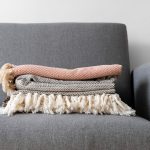 Close-up of deep-cushioned armchair with throw blanket draped over arm