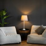 Living room setup with armchair, matching ottoman, and side table with lamp