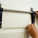 Step-by-step installation photos showing track mounting, hanger attachment, and door hanging process