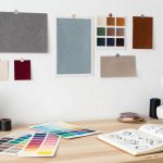 A designer’s workspace with mood boards, fabric samples, and color swatches displayed