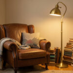 A cozy reading nook with a leather armchair, stacked vintage books, and a brass floor lamp casting warm light.
