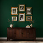 A deep forest green accent wall paired with dark wood furniture and gold picture frames.
