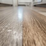 A vinyl plank floor in a modern kitchen with water splashed on the surface, illustrating waterproof capability, contrasted with a laminate floor showing a slight edge swell from moisture.