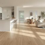 An open-plan home interior where luxury vinyl plank flooring flows seamlessly from a kitchen into a living area, demonstrating versatility and modern aesthetic appeal.