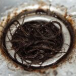 Close-up of hair-clogged drain strainer