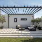 Minimalist 2026 patio with polished concrete floor, black steel pergola frame, outdoor sofa and potted olive trees