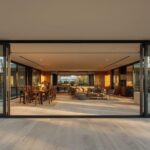 Modern Australian home with wide folding glass doors fully open connecting living room to alfresco entertaining area