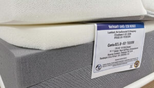 A close-up photo of high-density foam layers or a warranty certificatelabel on a mattress.
