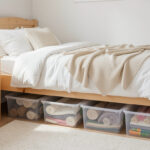 Clear rolling storage bins under a small bedroom bed