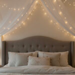 Fairy lights draped in a canopy above a bedroom headboard