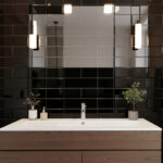 Glossy black tile accent wall behind a bathroom vanity