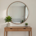 Large round mirror above a small apartment console table
