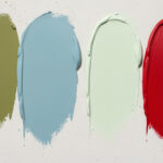 Several large paint sample swatches painted directly on a wall for side-by-side color comparison.