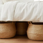 Woven seagrass baskets tucked under a bedroom bed